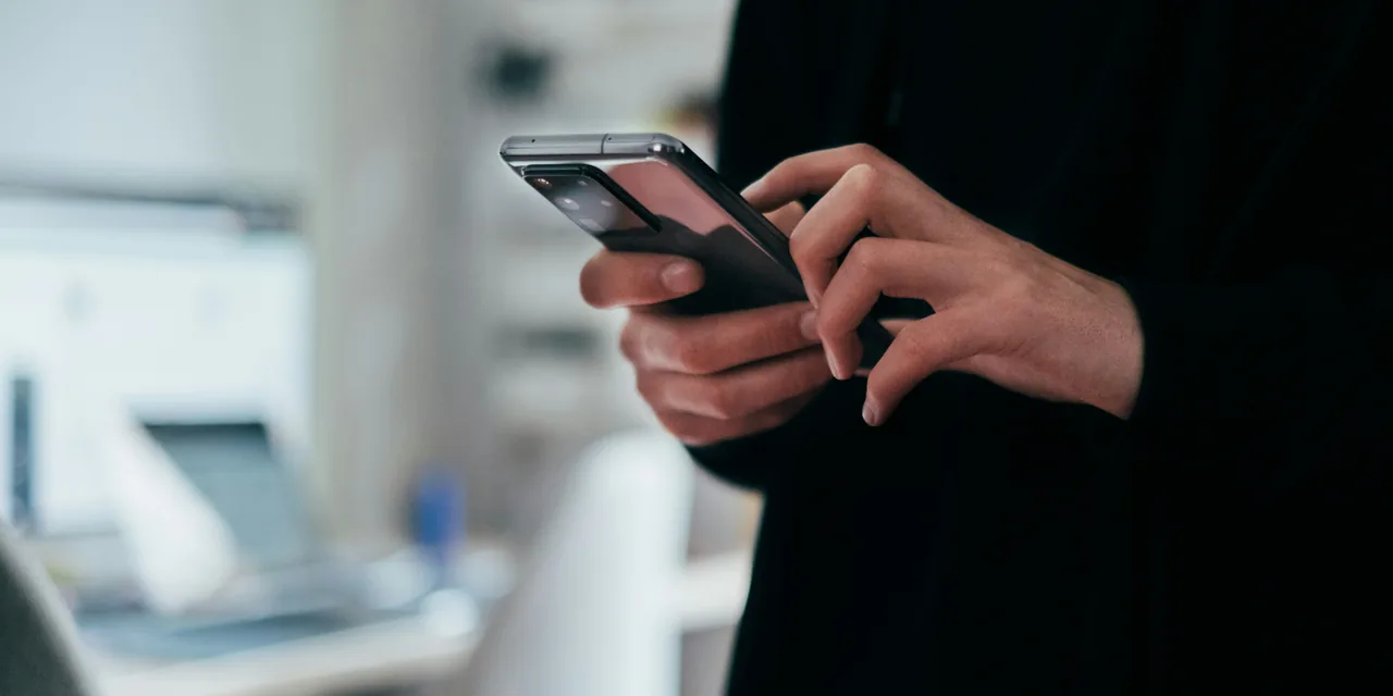 Žmogus telefonu tikrina draudimo kainas